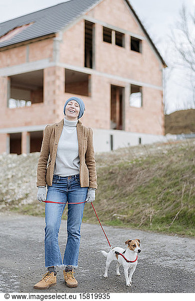 Portrait of happy mature woman going walkies with her dog