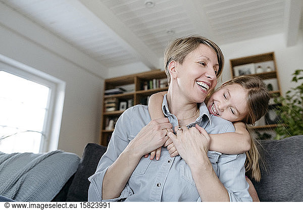 Portrait of happy mother and little daughter having fun together at home