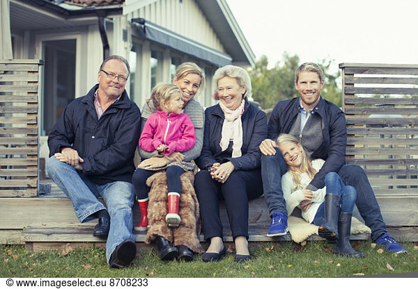 Portrait of happy multi-generation family sitting together in yard