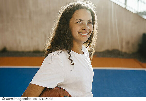 Portrait of happy pre-adolescent girl at sports court
