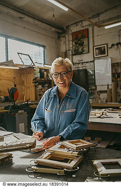 Portrait of happy senior female carpenter at repair shop
