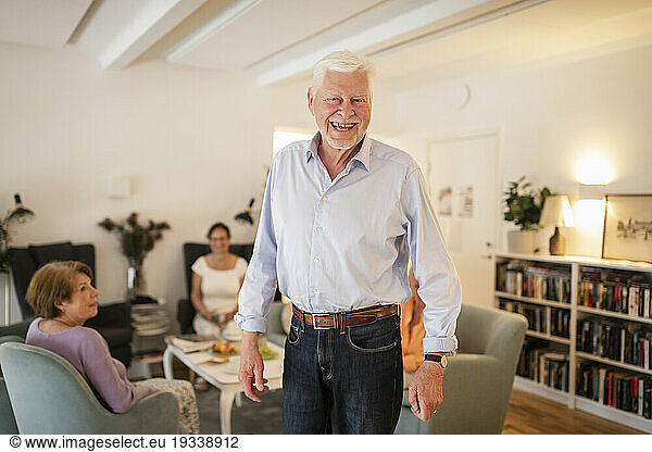 Portrait of happy senior man standing at nursing home