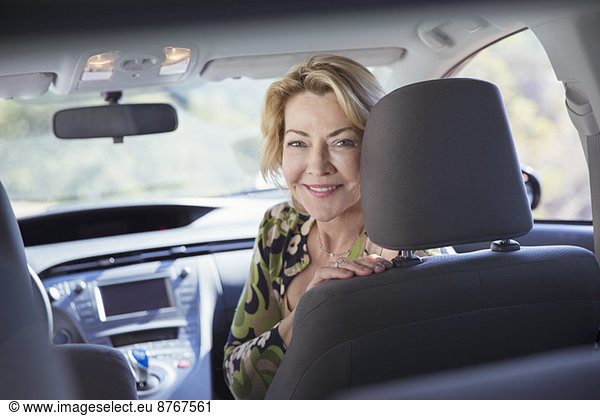 Portrait of happy senior woman inside of car