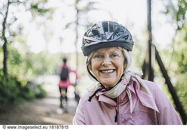 Portrait of happy senior woman wearing cycling helmet