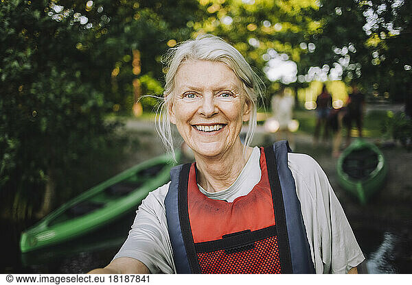 Portrait of happy senior woman wearing life jacket