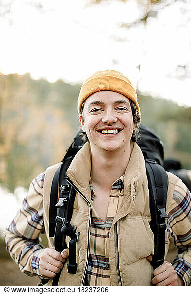 Portrait of happy young man wearing knit hat during hiking