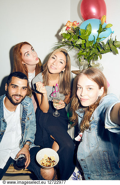 Portrait of happy young multi-ethnic friends enjoying party at apartment