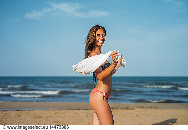 Portrait of happy young woman wearing bikini on the beach