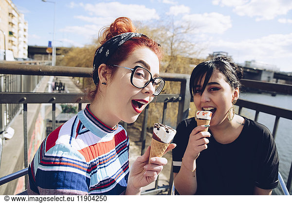 Portrait of hipster female friends eating ice cream in city