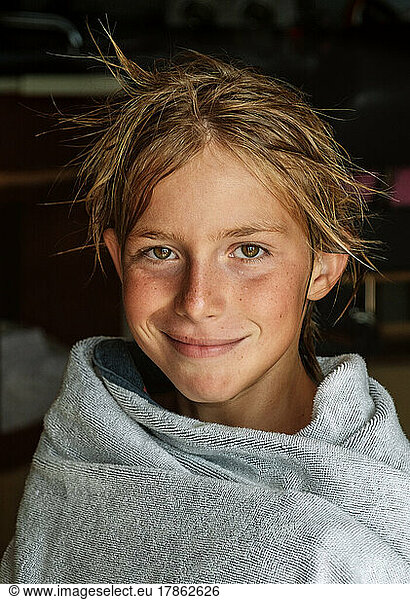 Portrait of kid wrapped towel after swimming.