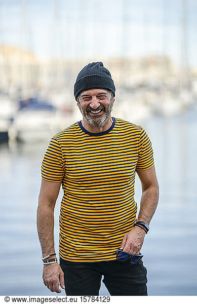 Portrait of laughing mature man wearing cap and striped t-shirt  Alicante  Spain
