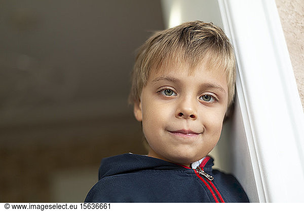 Portrait of little boy leaning against door case