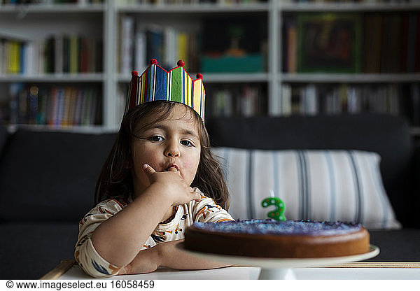 Portrait of little girl tasting birthday cake