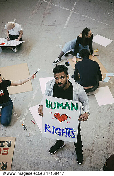 Portrait of male activist holding human rights poster