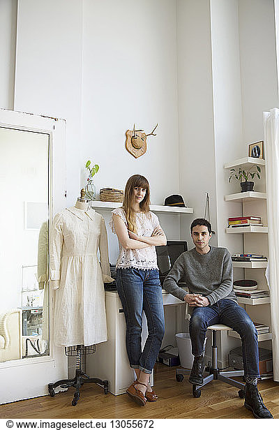 Portrait of male and female fashion designer in studio