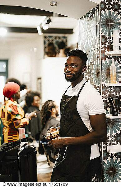 Portrait of male barber standing at hair salon