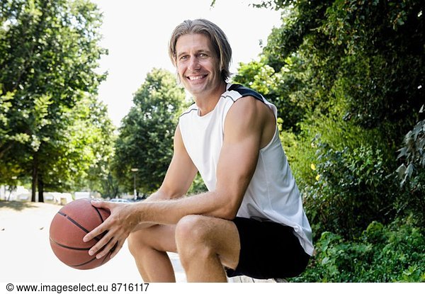Portrait of male basketball player taking a break in park