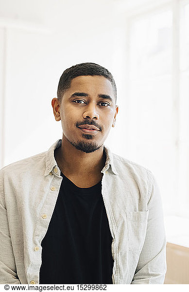 Portrait of male computer programmer standing in office