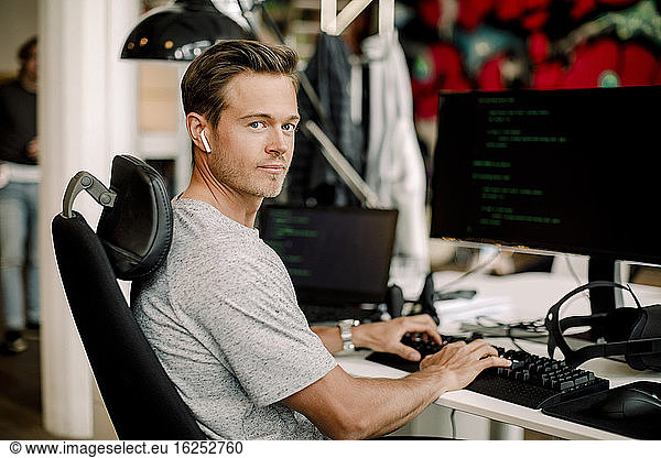 Portrait of male computer programmer working in office