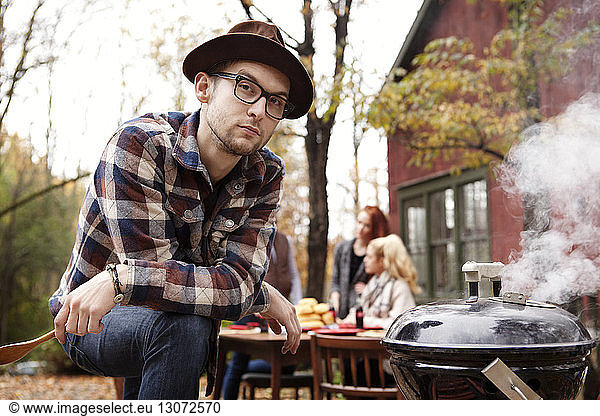 Portrait of man preparing food while friends at table