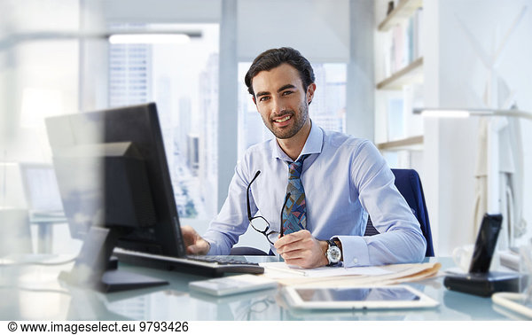Portrait of man sitting at his desk in office