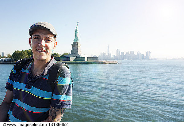 Portrait of man standing against Statue of Liberty