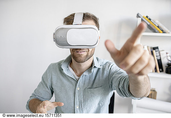Portrait of man wearing VR glasses in office