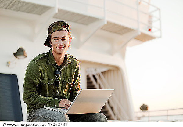 Portrait of man with laptop computer on ship