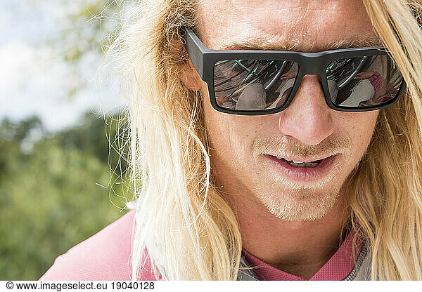 Portrait Of Man With Long Hair Wearing Sunglasses