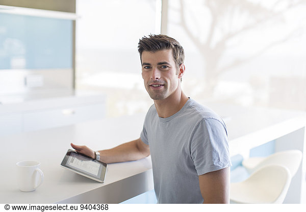 Portrait of man with tablet pc in kitchen