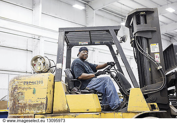 Portrait of manual worker driving forklift at metal Steel Mill
