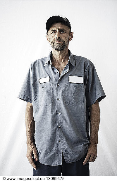 Portrait of manual worker standing against white background