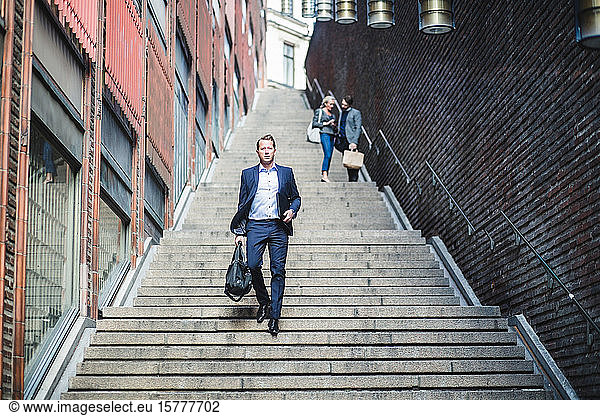 Portrait of mature businessman climbing steps