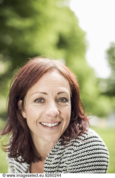 Portrait of mature businesswoman smiling at park