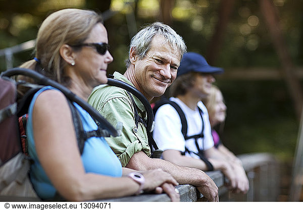Portrait of mature hiker standing with family in forest