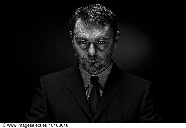 Portrait of mature man against black background  close up