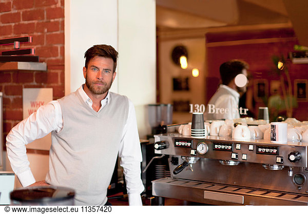 Portrait of mature man behind counter in cafe