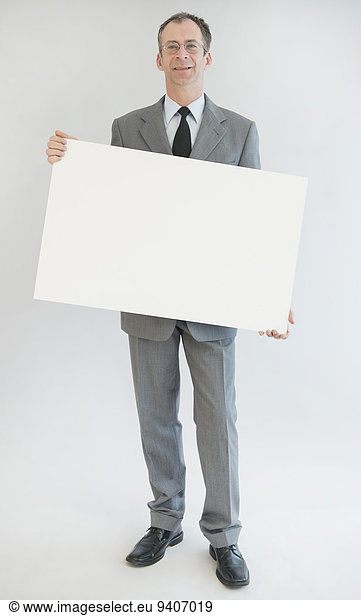 Portrait of mature man holding blank whiteboard  smiling