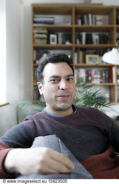 Portrait of mature man sitting on couch at home