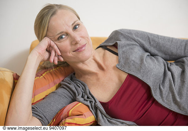 Portrait of mature woman relaxing on couch  smiling