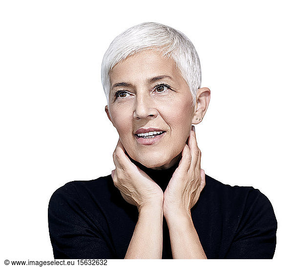 Portrait of mature woman with short grey hair and brown eyes against white background