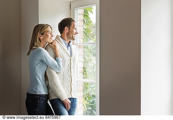 Portrait of mid adult couple looking out of window