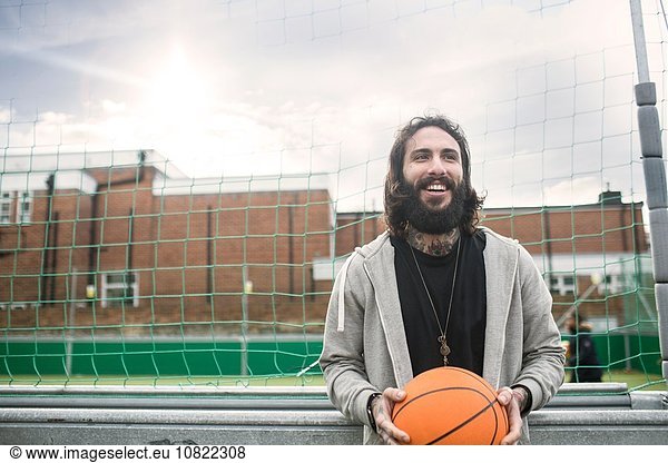 Portrait of mid adult man holding basketball