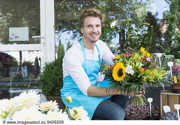 Portrait of mid adult man holding bunch of flower  smiling