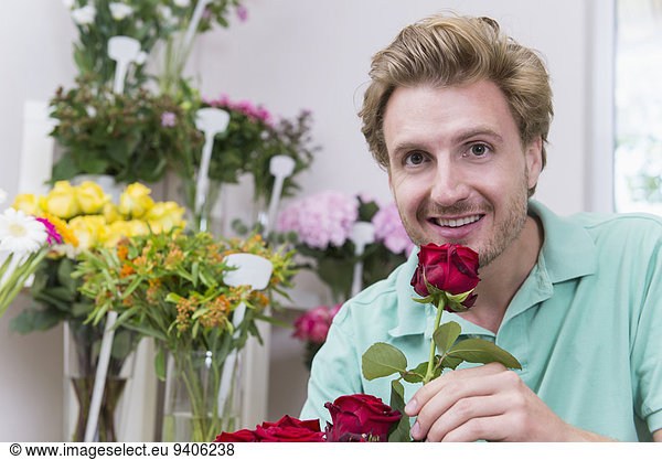 Portrait of mid adult man holding red rose  smiling
