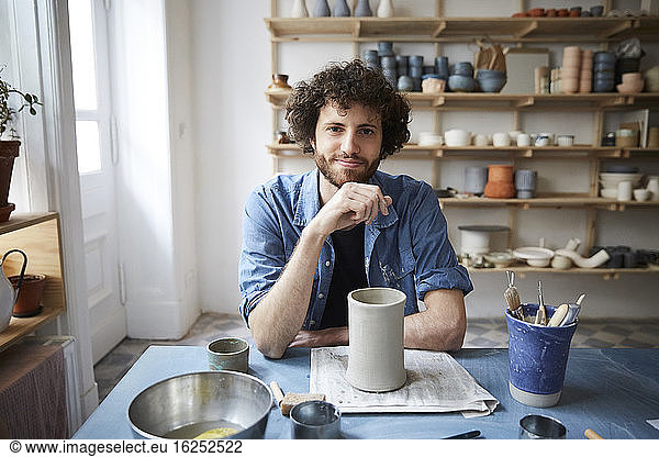 Portrait of mid adult man sitting in pottery class