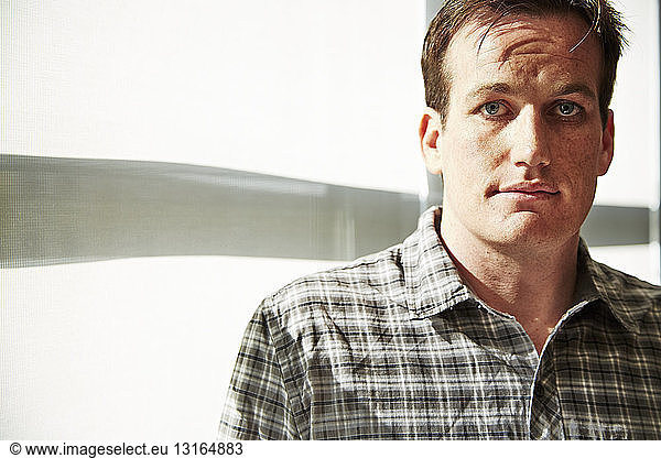 Portrait of mid adult man wearing checked shirt
