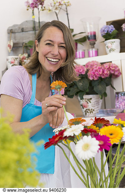 Portrait of mid adult woman holding flower  smiling