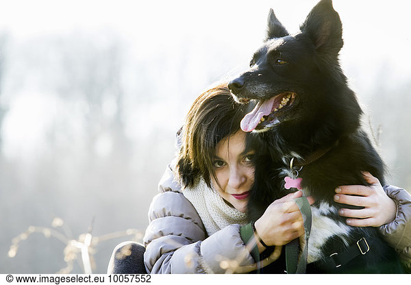 Portrait of mid adult woman hugging her dog