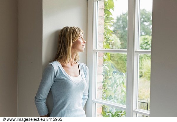 Portrait of mid adult woman looking out of window